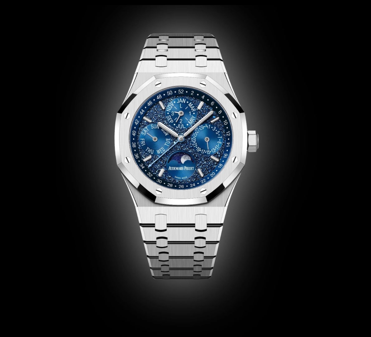 A steel perpetual calendar wristwatch with a blue dial, on black